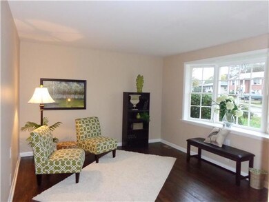 This living room, with the large picture window, has  newly refinished hardwood floors.  A coat closet is also in this lovely room.