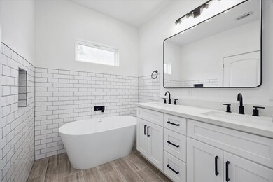 This gorgeous primary bathroom has a subway tiled