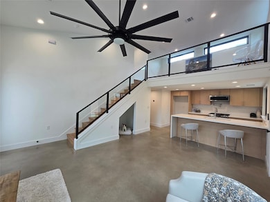 Living area with concrete flooring, a high ceilin