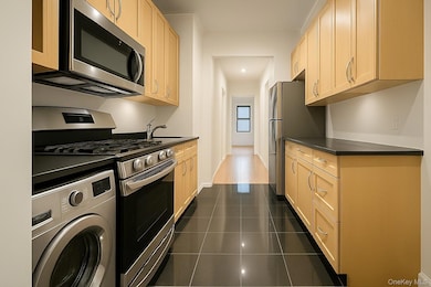 Kitchen with washer / clothes dryer, stainless steel appliances, light brown cabinets, and recessed lighting