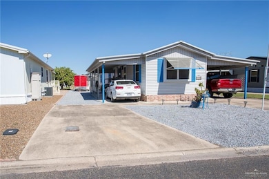 Manufactured / mobile home featuring a carport and driveway