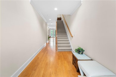 Hallway featuring wood-type flooring and crown mol