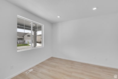 Empty room with wood finished floors, baseboards, and recessed lighting