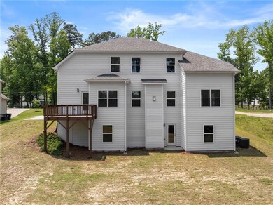 Back of property with a yard, a shingled roof, central AC unit, and a wooden deck