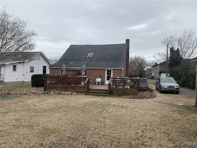 Back of property featuring brick siding, a yard, a