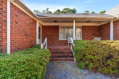 Doorway to property featuring brick siding and a porch