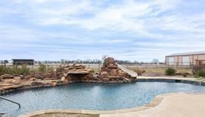 Pool featuring a water slide and fence
