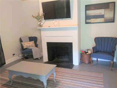 Living area with a fireplace with flush hearth and baseboards