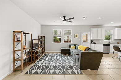Living area with a ceiling fan, light tile patter