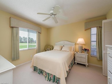 Bedroom featuring light carpet, baseboards, a ceiling fan, and a textured ceiling