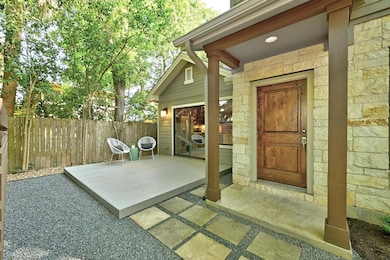 Entrance to property featuring fence and stone si