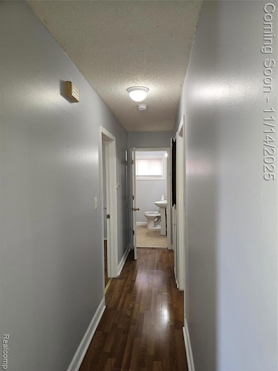 Hall featuring dark wood finished floors and a textured ceiling