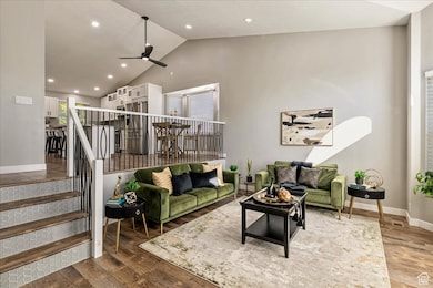 Living area featuring wood finished floors, ceiling fan, recessed lighting, and high vaulted ceiling