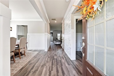 Foyer entrance featuring a wainscoted wall and dark wood finished floors