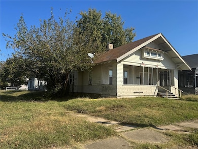 View of front of home with covered porch, a chimney, and a front yard