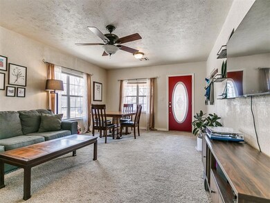 Carpeted living room featuring a ceiling fan