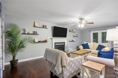 Living room with baseboards, a ceiling fan, dark w