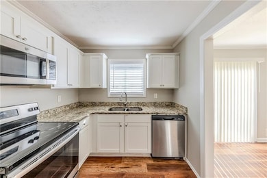 Kitchen featuring light stone countertops, white c