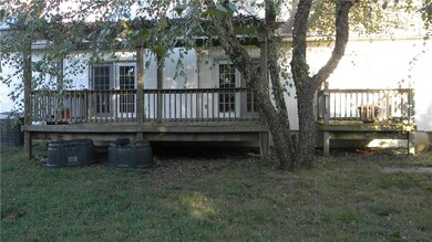 COVERED WEST SIDE DECK WITH SHADE TREES.
