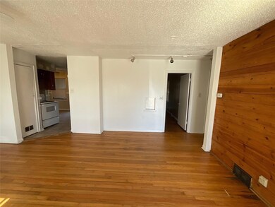 Spare room featuring wood walls, hardwood / wood-s
