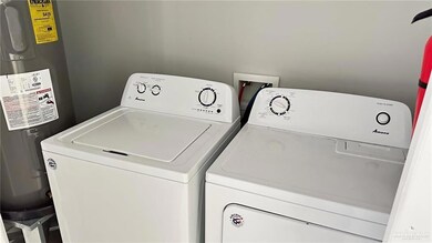 Washroom featuring water heater and independent washer and dryer
