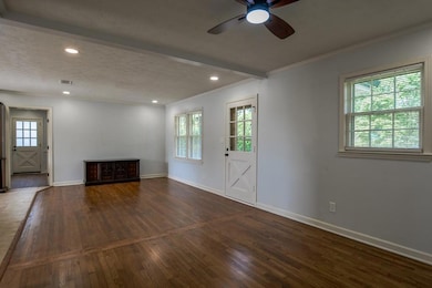 Unfurnished living room featuring ceiling fan, wood finished floors, crown molding, a textured ceiling, and recessed lighting