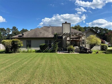Back of property with a pergola, a patio area, a lawn, and a shingled roof