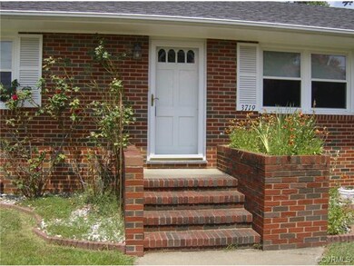 Front Entry...Showing Concrete sidewalk, Brick & Concrete stoop with Built-In Flower Box, Storm Door, Thermal/Tilt Replacement Windows (w/ transferable warranty) and Shutters