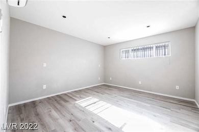 Unfurnished room with wood finished floors and bas