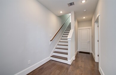 This is a modern, well-lit hallway featuring a sta