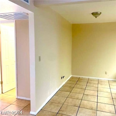 Empty room with light tile patterned floors and ba
