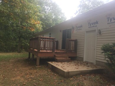 back view of home showing deck and sideing damage.  owner has contractor working on sideing and will be completed soon