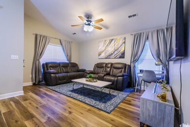 Living room with wood-type flooring, vaulted ceili