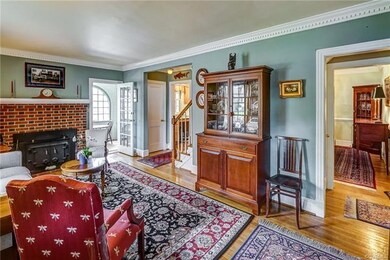 View of living area with hardwood floor and nice moldings
