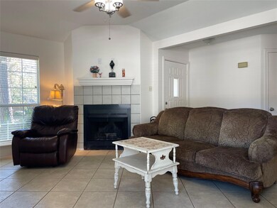 Living area featuring a ceiling fan, vaulted ceil