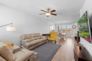 Living room with a ceiling fan, visible vents, ba