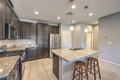 Kitchen featuring dark brown cabinetry, visible ve