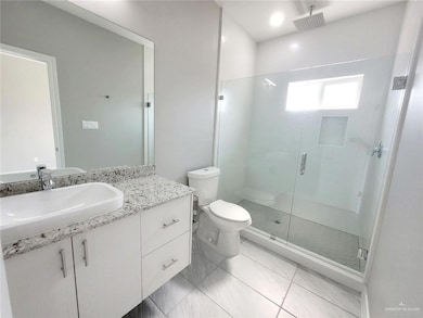 Full bathroom featuring vanity, toilet, and a shower stall