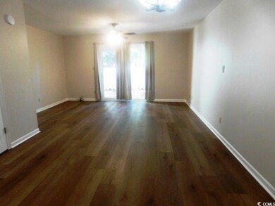 Unfurnished room featuring ceiling fan and dark ha