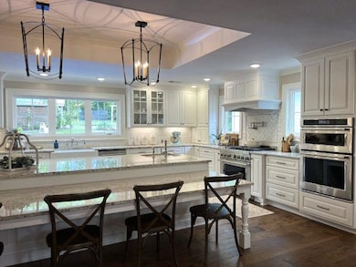 Kitchen featuring white cabinets, decorative backs