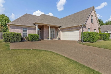 View of front facade featuring a shingled roof, brick siding, and a front lawn