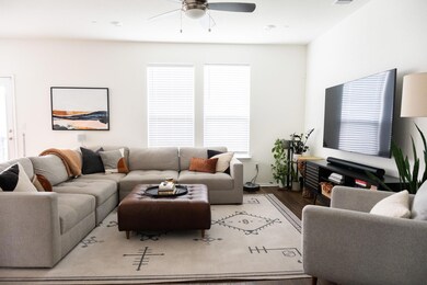 Living area with ceiling fan and wood finished fl