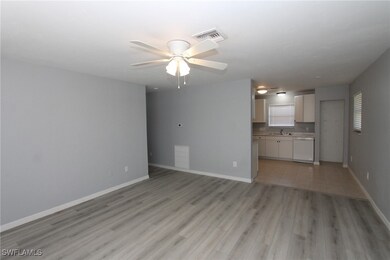 Unfurnished living room featuring sink, light hard