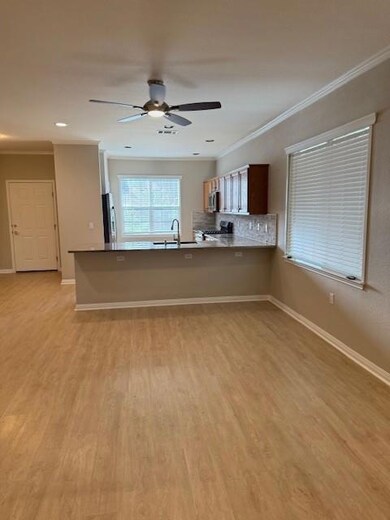 Kitchen featuring crown molding, a peninsula, lig