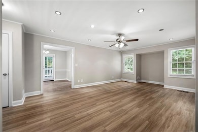 Spare room featuring wood finished floors, crown molding, ceiling fan, and recessed lighting