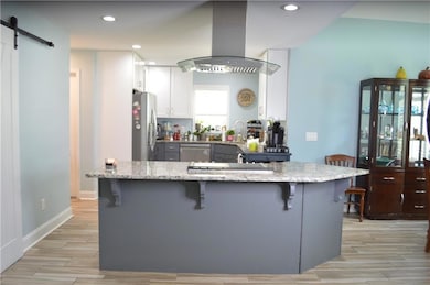 Kitchen with light stone counters, a breakfast bar