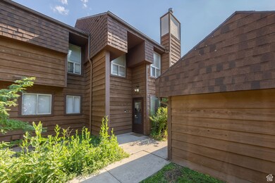 Entrance to property with a chimney and a shingled roof