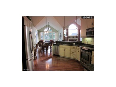 The kitchen has hardwood floors and granite counte