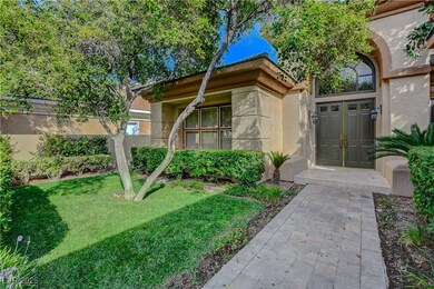 View of exterior entry with stucco siding and a yard