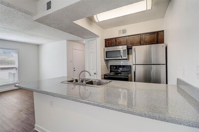 Kitchen with stainless steel appliances, sink, bac